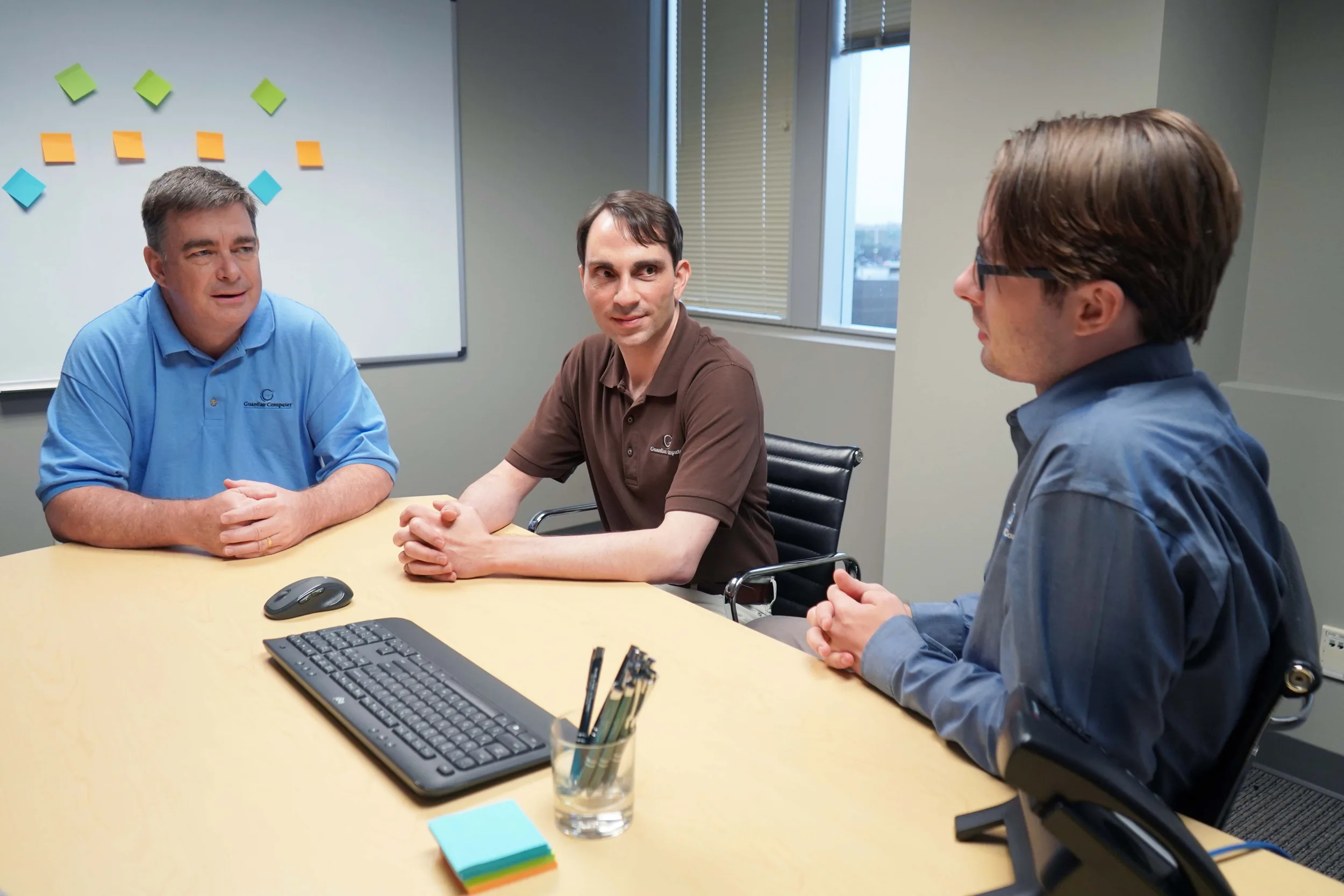 Three members of the Guardian Computer team talking through a client's technology